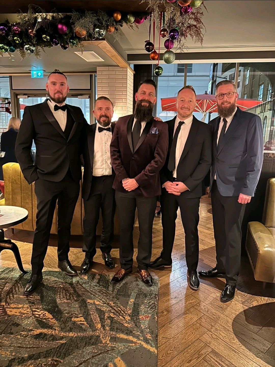 Pictured in Black Tie are Site Support Nigel Kennedy, Head of Technical and Customer Service Dean Asher and Head of Marketing Jason Nightingale with representatives from Bubble Darren Hunter and Chris Peacock. They are stood in a bar beneath a festive garland adorned with Baubles.